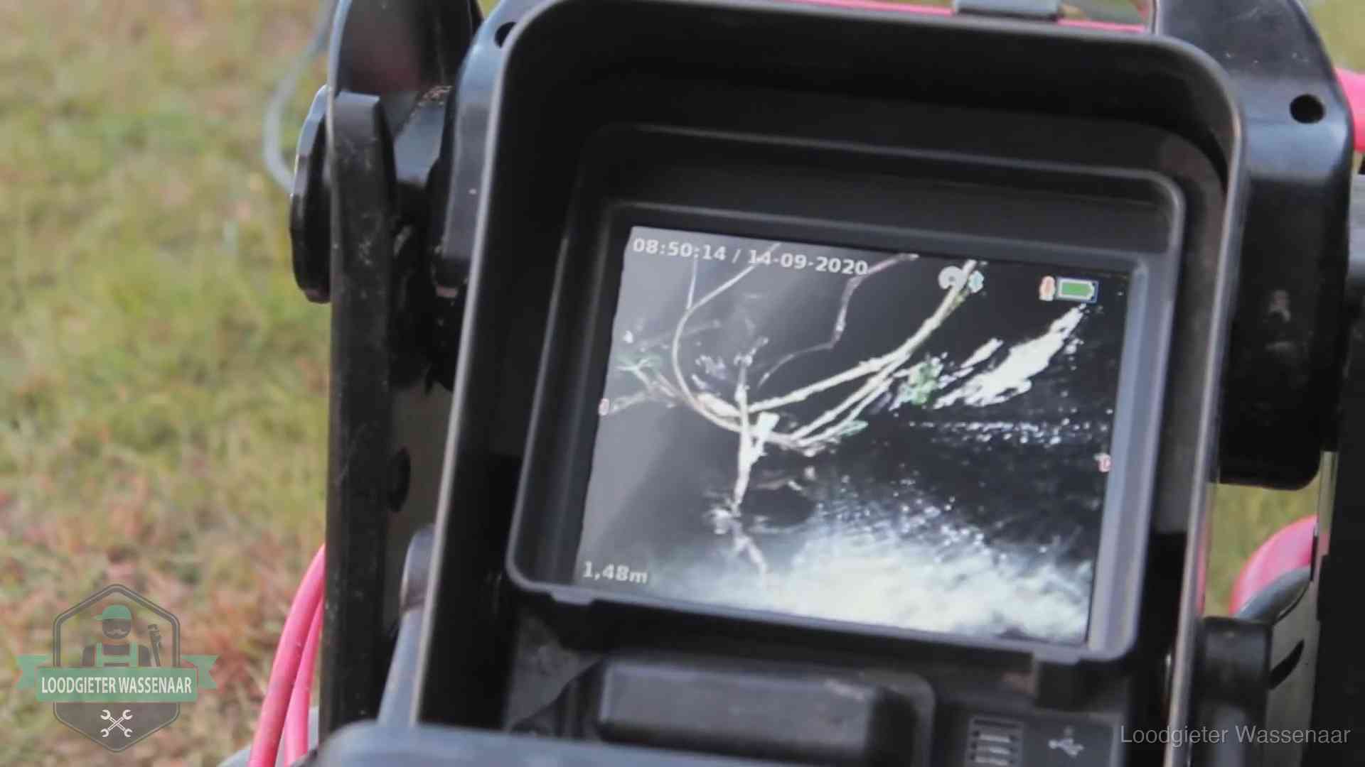 Monitor van een rioolcamera toont wortelingroei in de rioolbuis bij een woning in Wassenaar