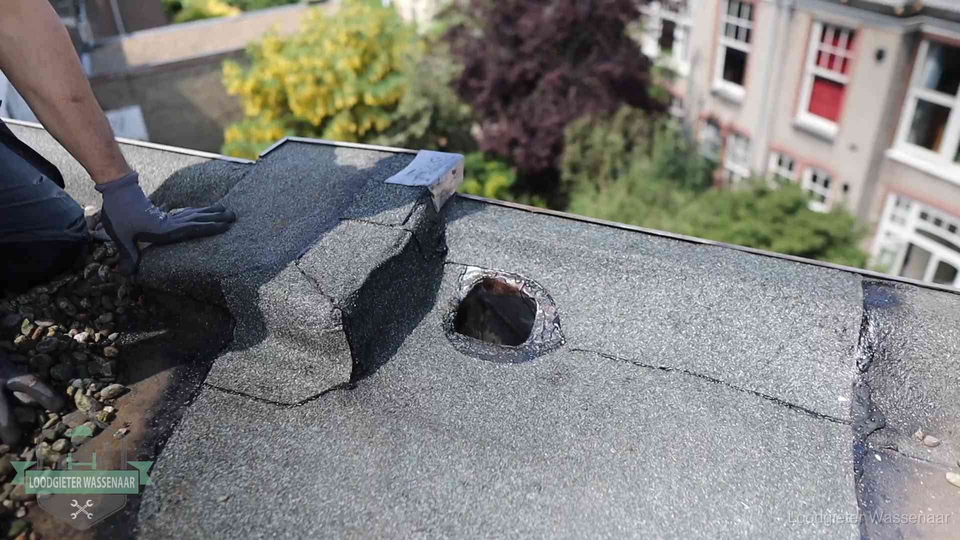 Daklekkage-inspectie op een plat dak in Wassenaar Loodgieter inspecteert een beschadigd bitumen plat dak tijdens een daklekkage-inspectie in Wassenaar