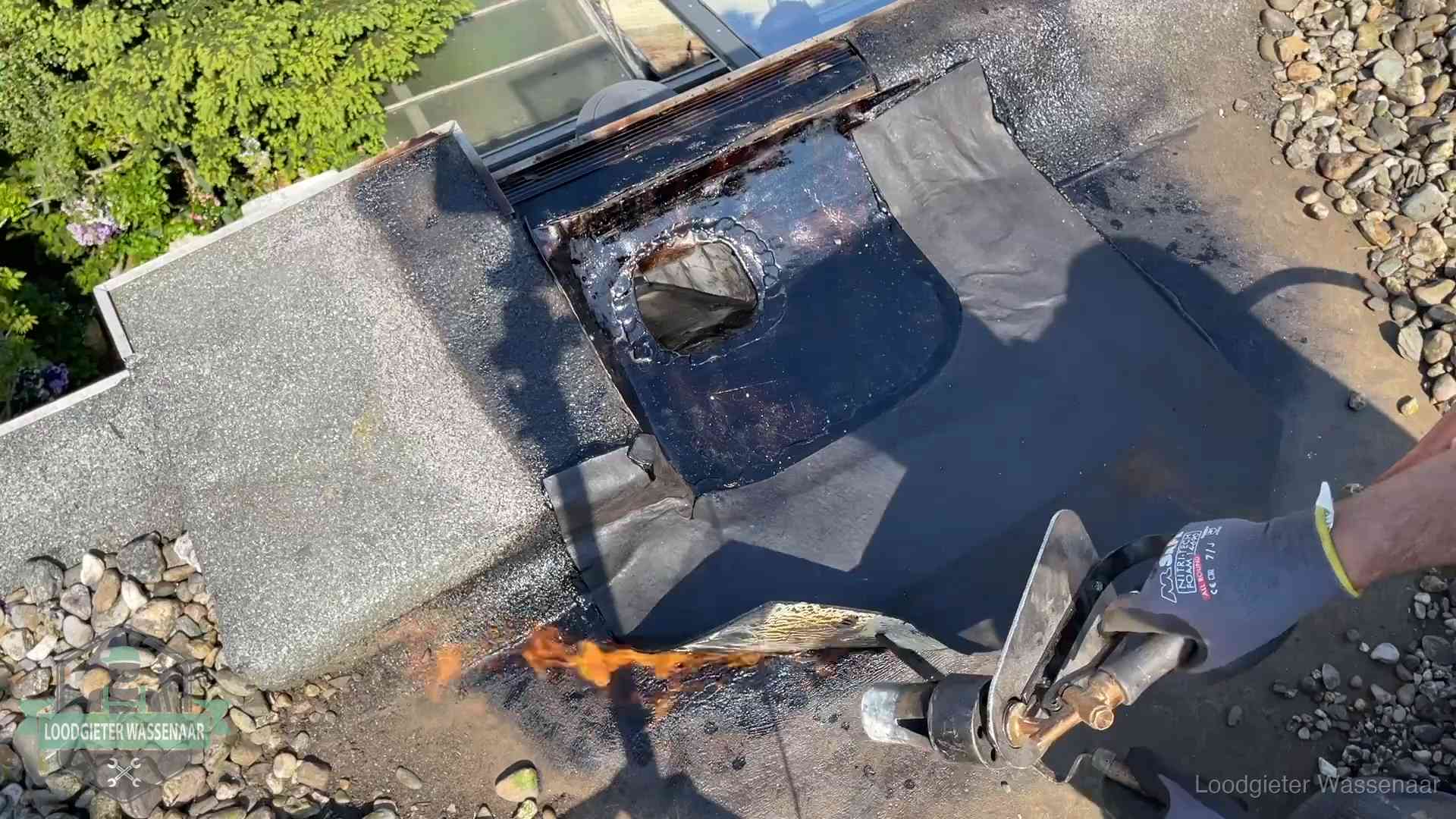 Daklekkage repareren in Wassenaar Dakdekker brandt bitumen rond een doorvoer tijdens een daklekkage-reparatie in Wassenaar