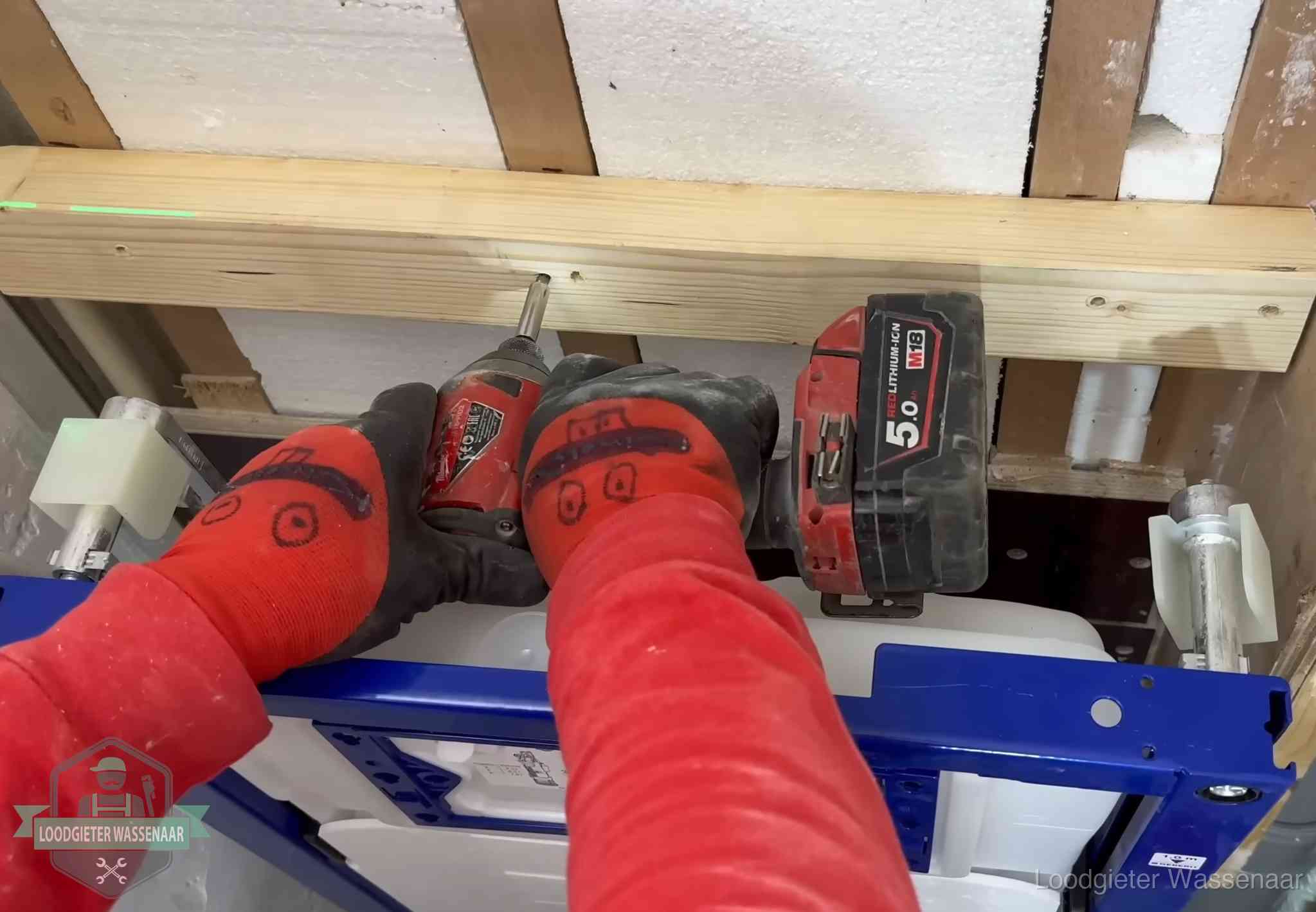 Monteur bevestigt een inbouwreservoir voor een hangend toilet in Wassenaar