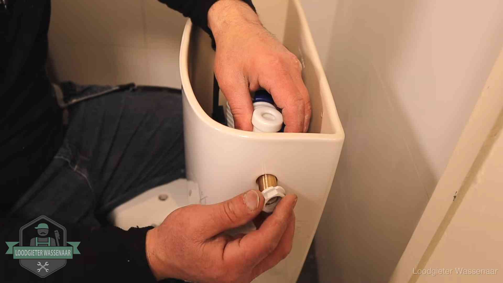 Loodgieter monteert de vlotterkraan van een stortbak bij een toilet in Wassenaar