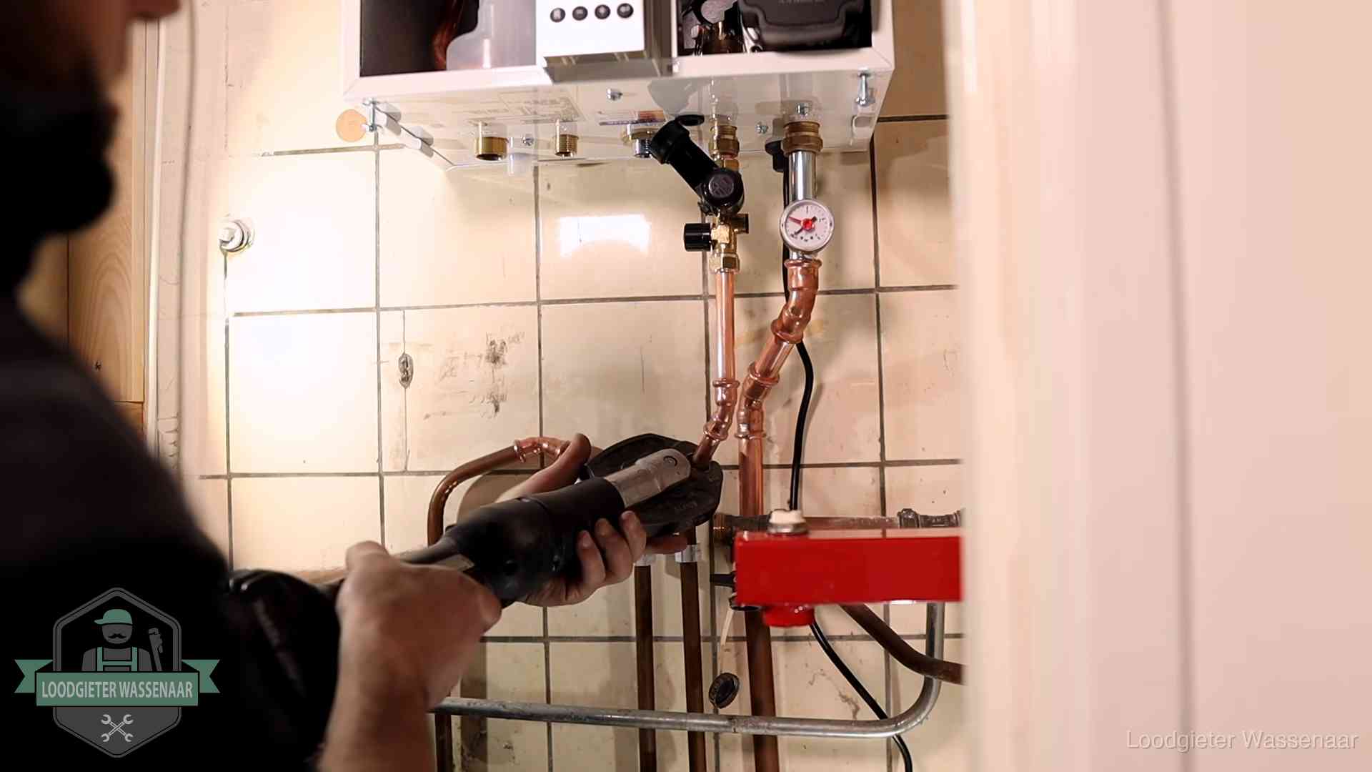 Cv-ketel onderhoud in Wassenaar Monteur werkt aan de leidingen onder een cv-ketel in Wassenaar
