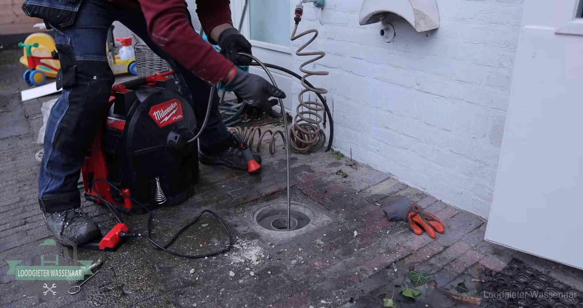 Ontstoppingsputje in de bestrating naast de gevel van een woning in Wassenaar
