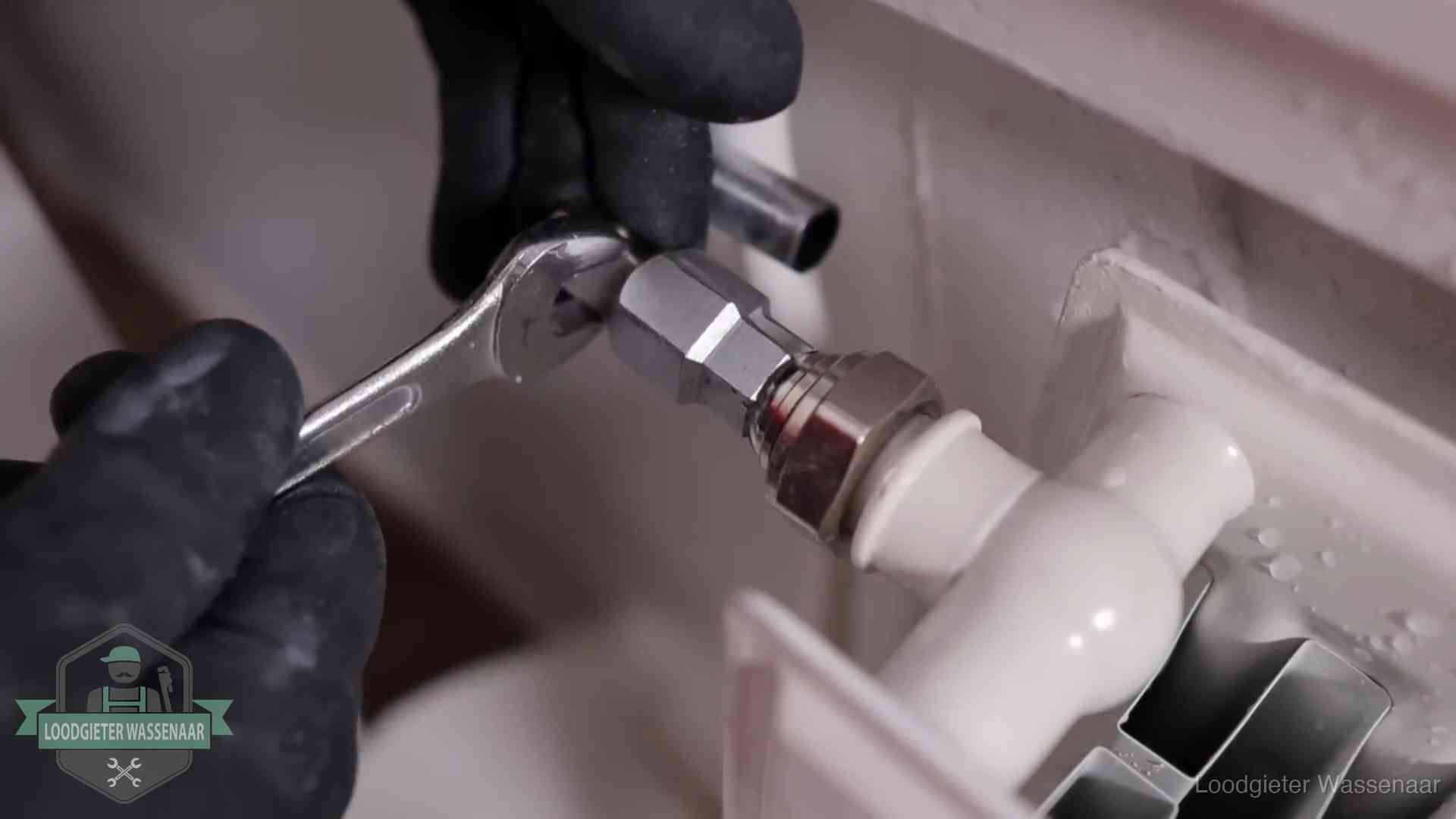 Radiatoren en waterzijdig inregelen in Wassenaar Steeksleutel draait een wartelkoppeling op een radiatorkraan aan in Wassenaar