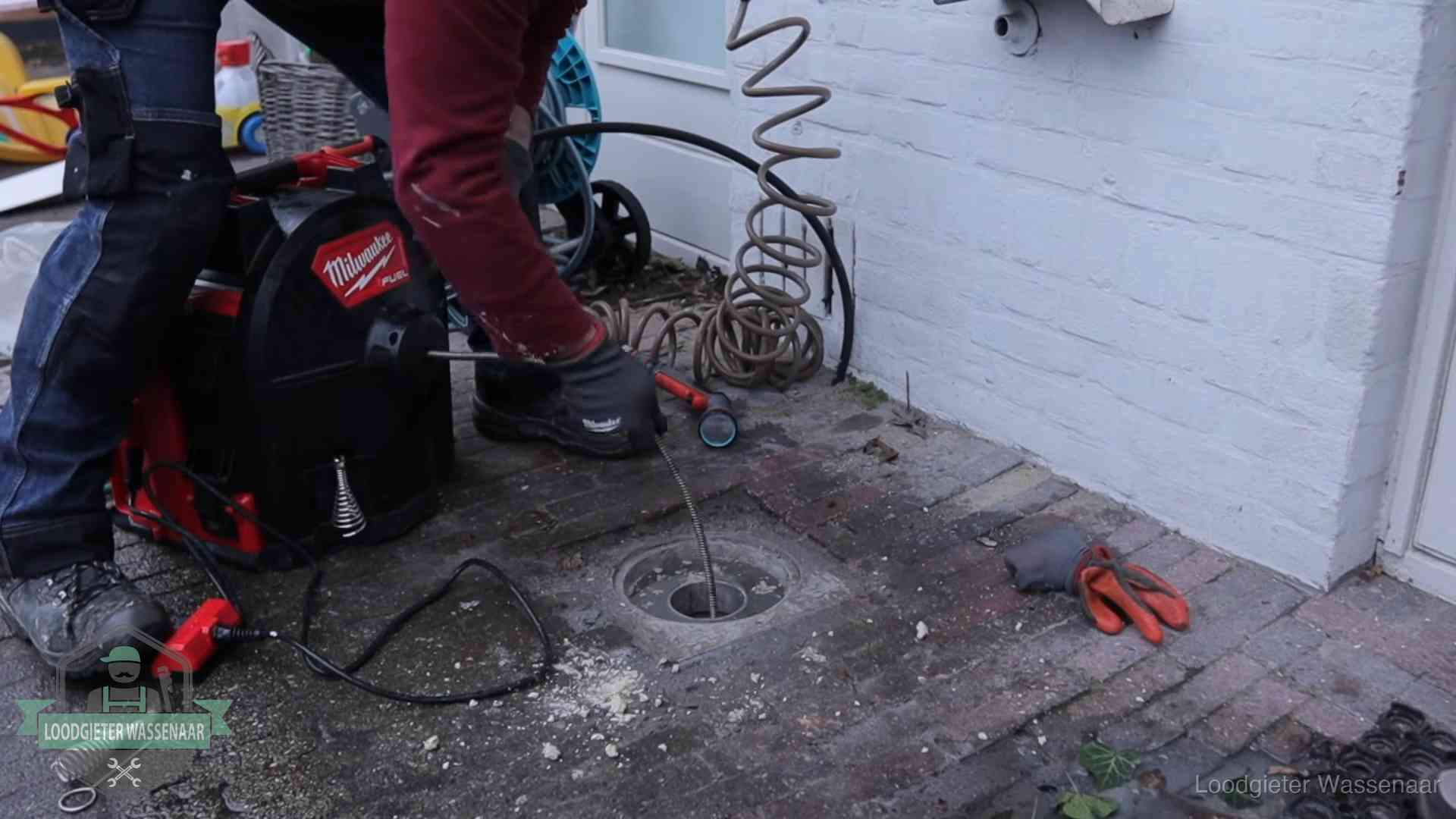 Spiraalmachine bij een ontstoppingsputje in de bestrating in Wassenaar