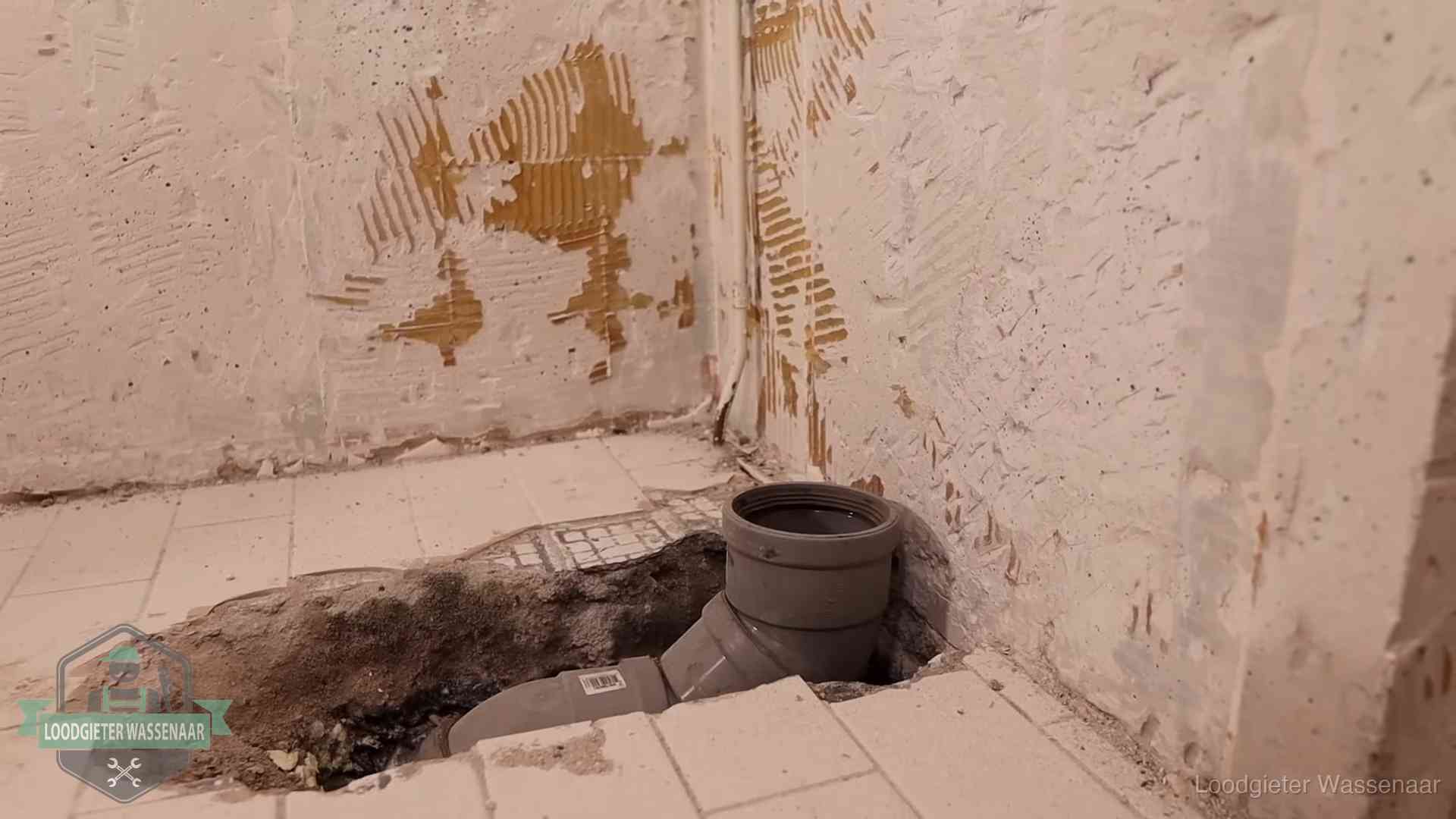 Opengebroken vloer met een nieuwe pvc-rioolbocht in een gegraven sleuf in Wassenaar