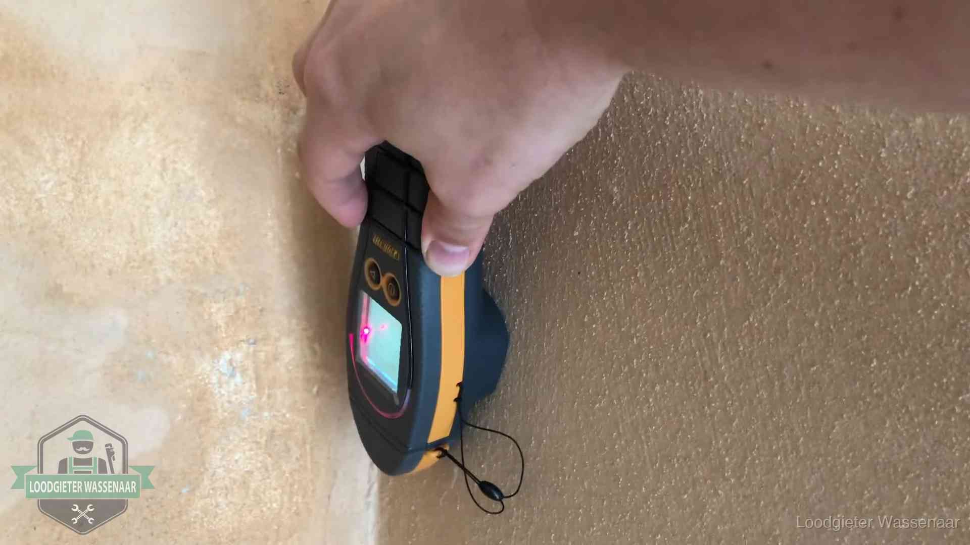 Daklekkage opsporen zonder hakwerk in Wassenaar Vochtmeter tegen een muur met vochtplekken tijdens het opsporen van een daklekkage in Wassenaar