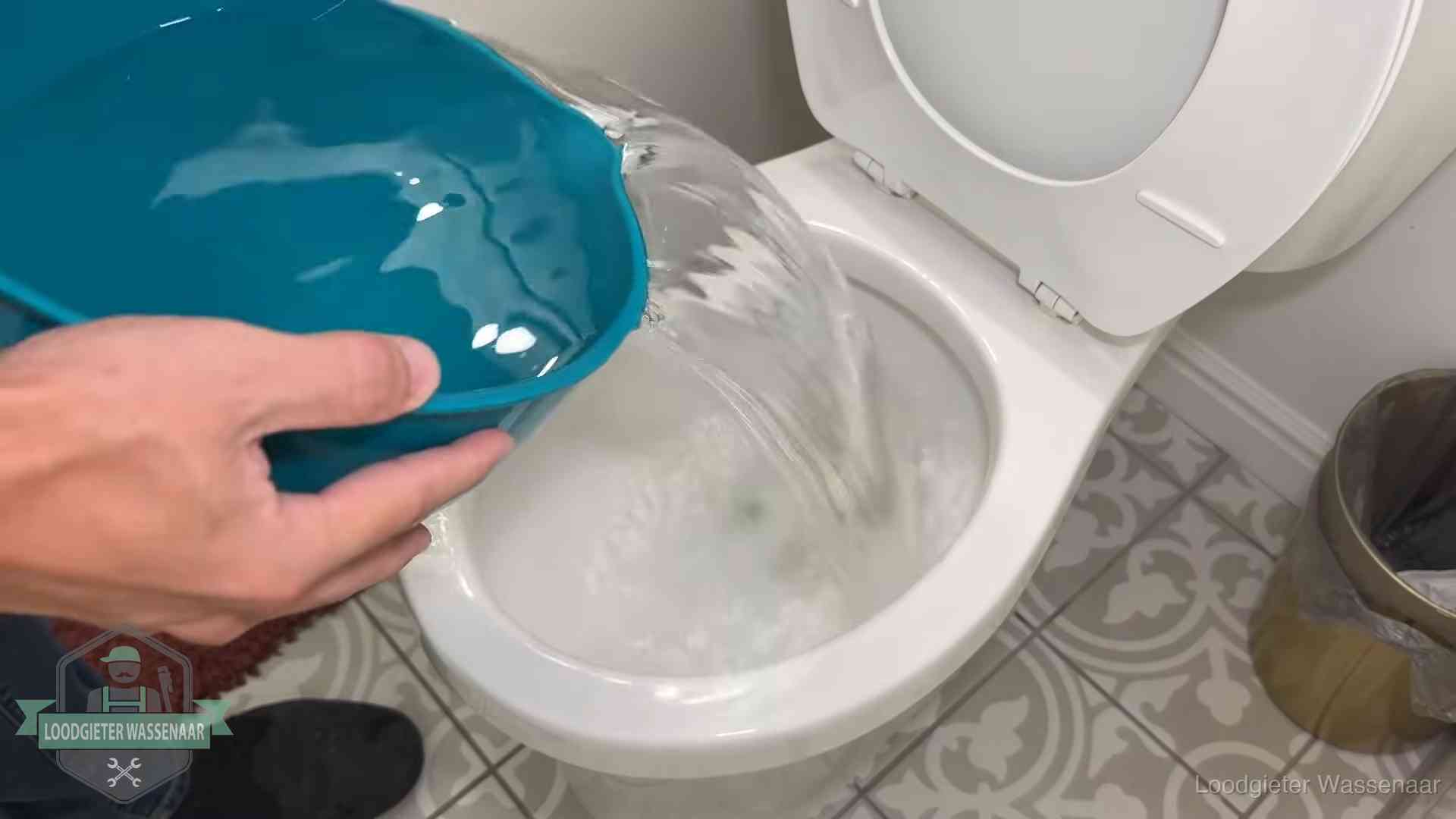 Warm water wordt voorzichtig in de wc-pot gegoten in Wassenaar