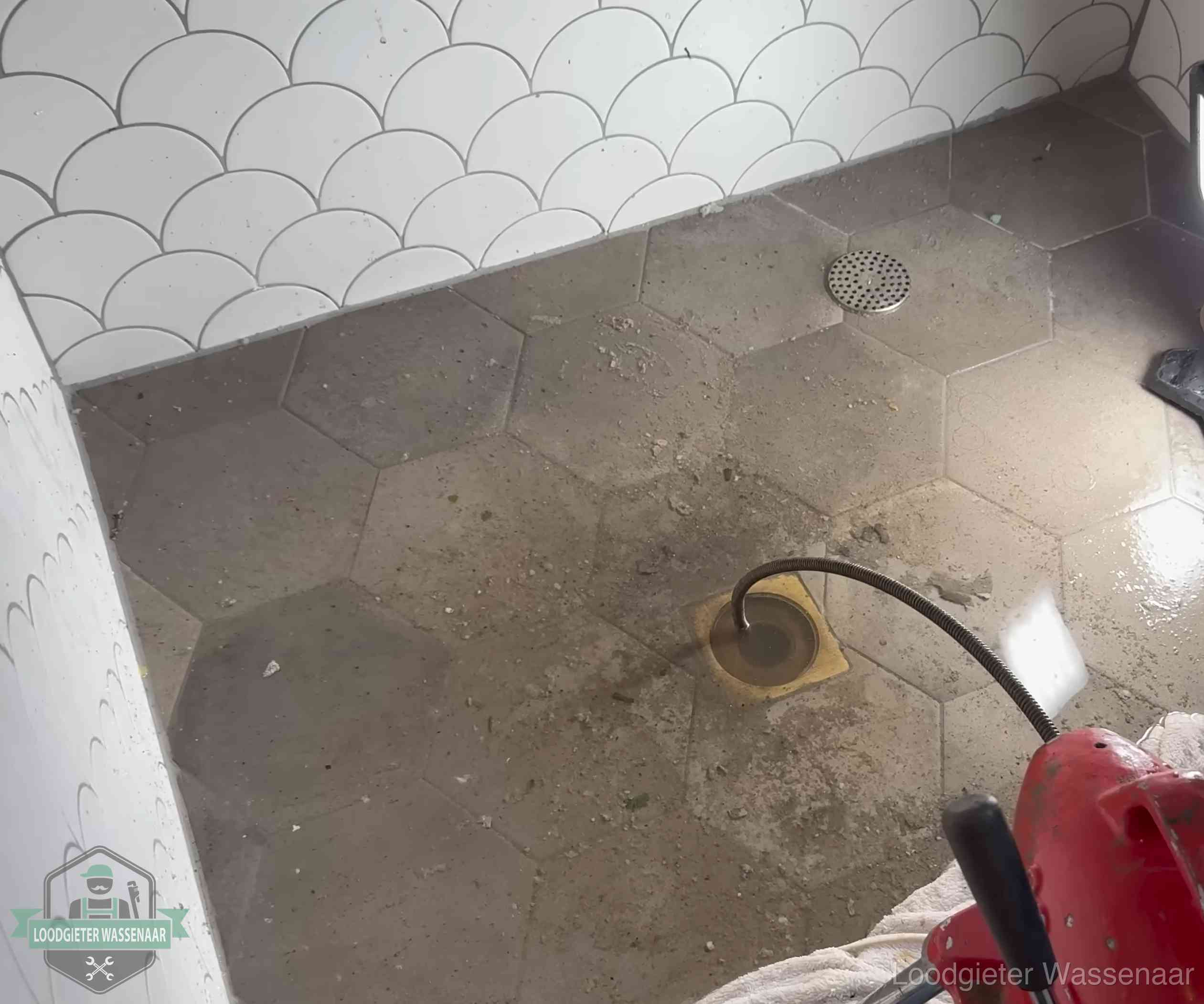 Vloerput met waterslot in een badkamer in Wassenaar, een bron van stank als het waterslot droogstaat