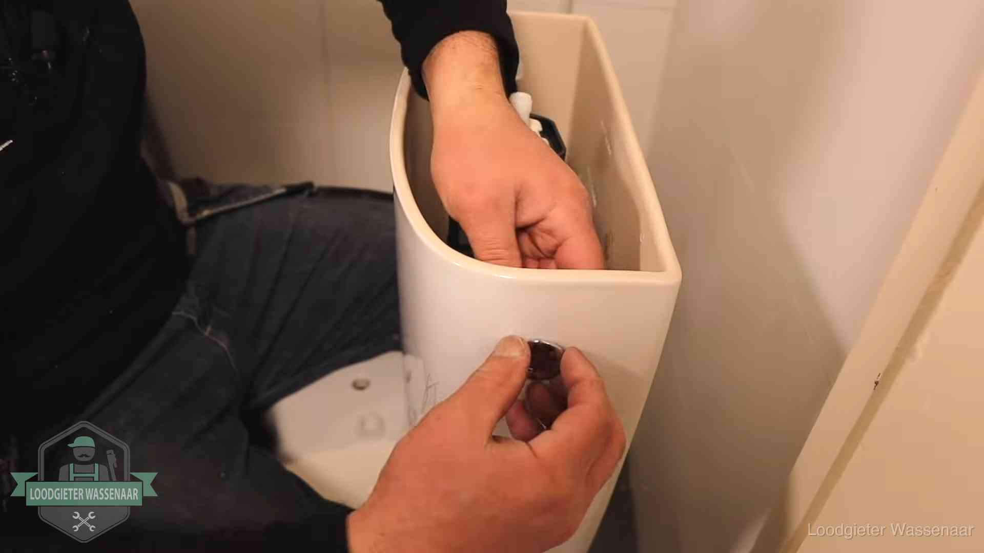 Drukknop van een duoblok-stortbak wordt gemonteerd bij een toilet in Wassenaar