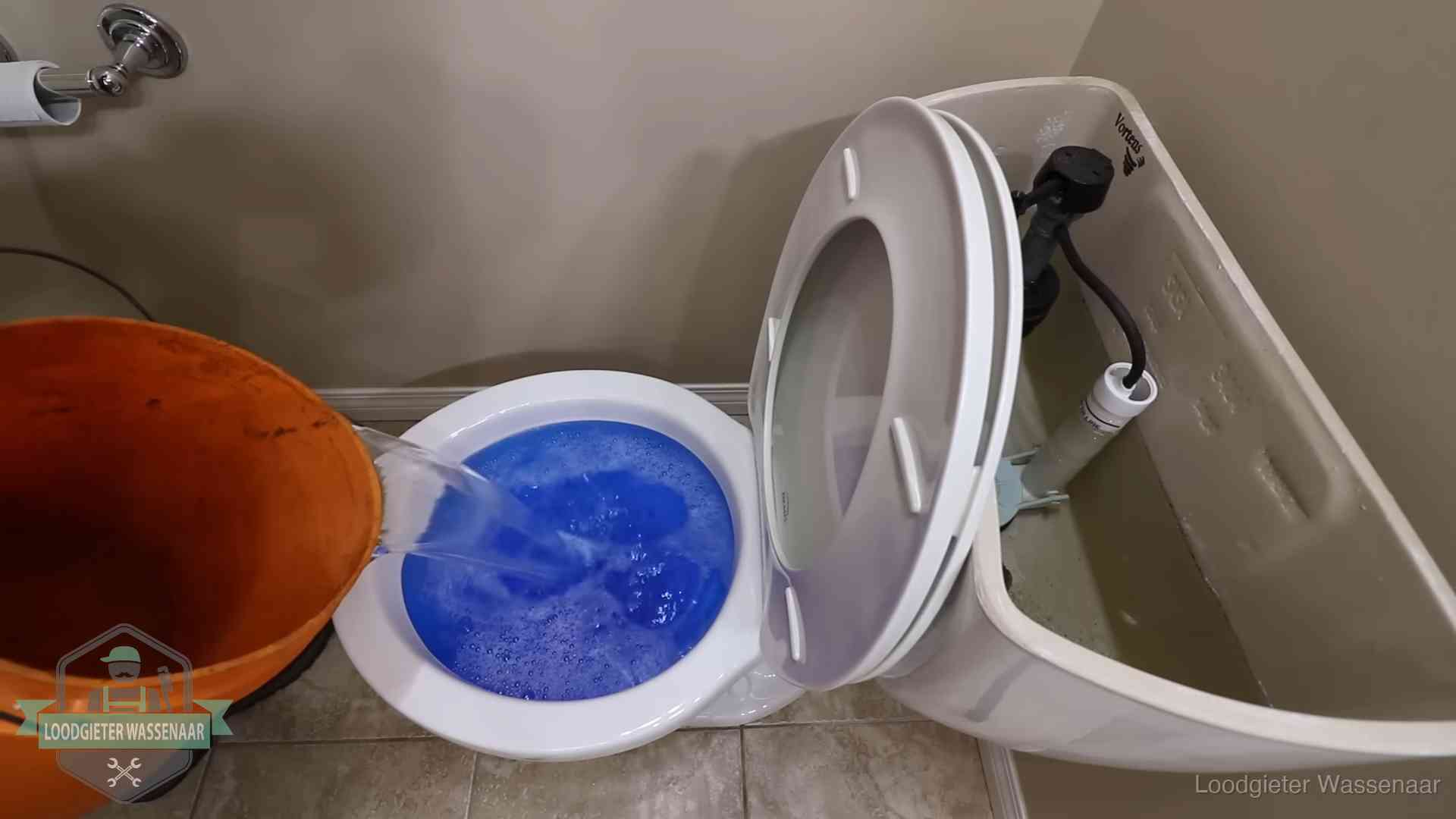 Water bij de wc-pot wordt met een emmer weggewerkt om schade te beperken in Wassenaar